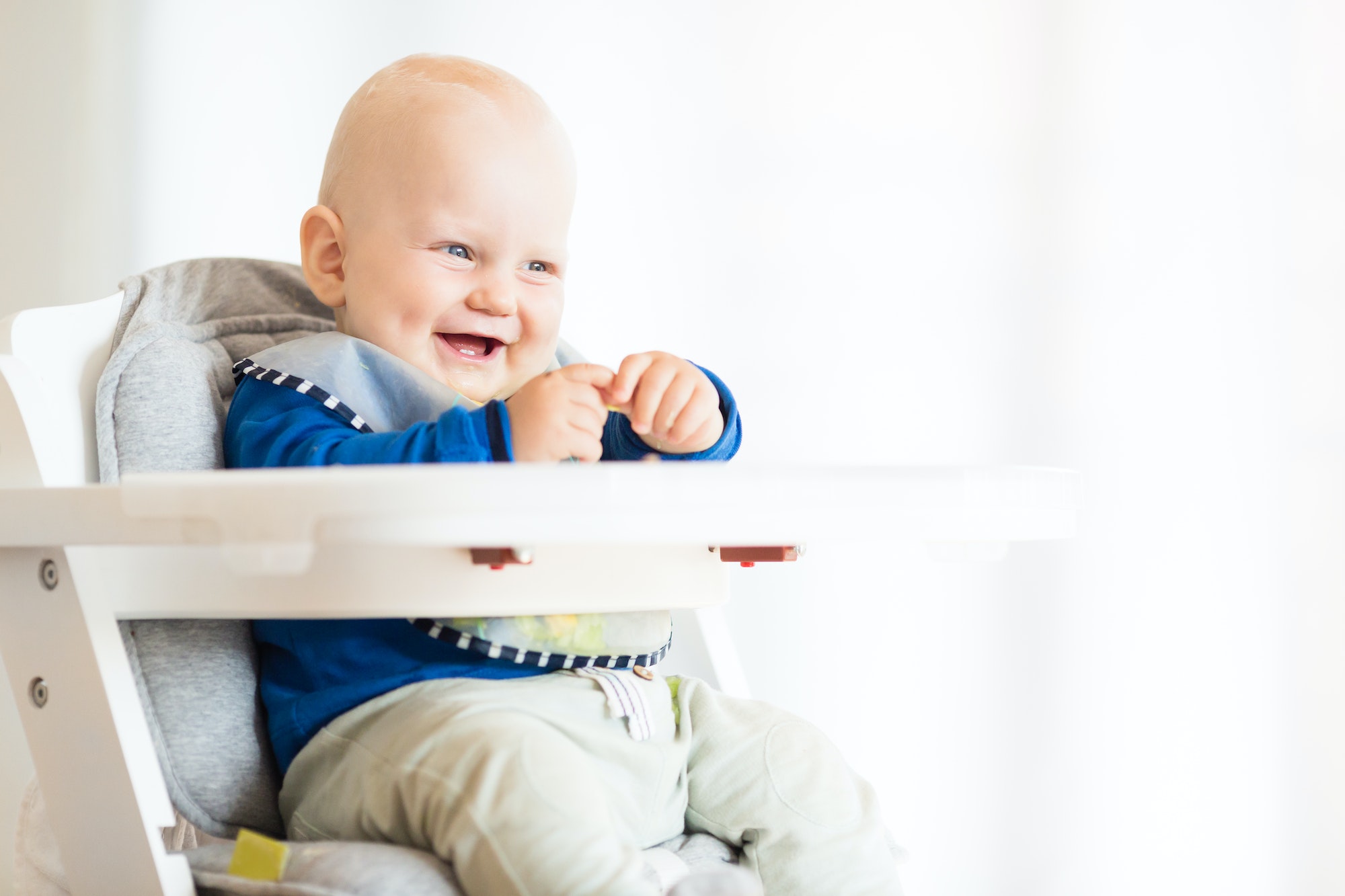 Baby boy eating with BLW method, baby led weaning